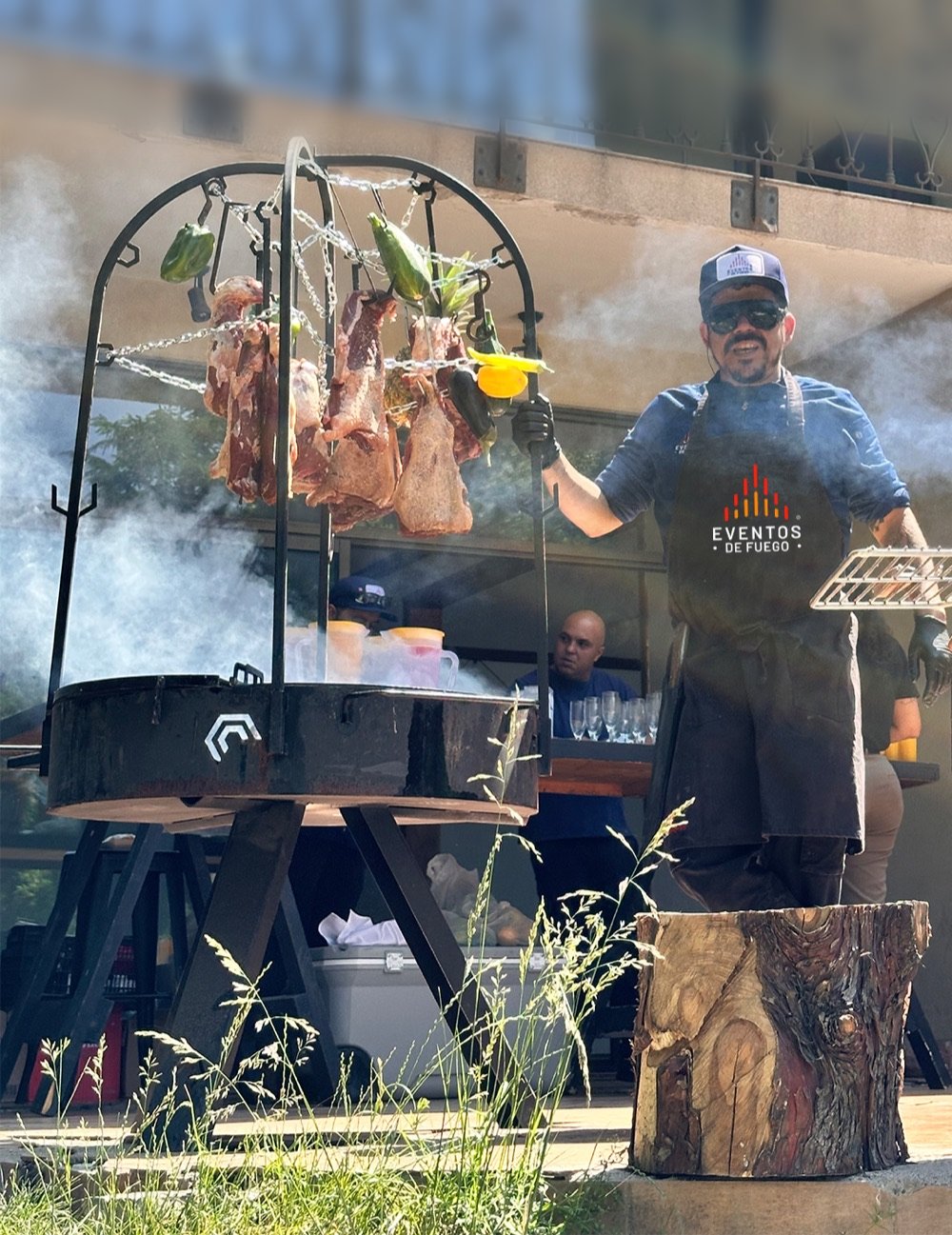 Parrillero de Eventos de Fuego preparando un asador circular en un evento